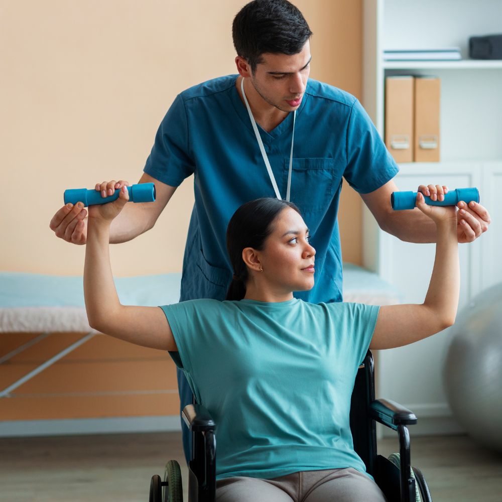 a MedCadre occupational therapist helping a patient in a wheelchair perform arm exercises with dumbbells.